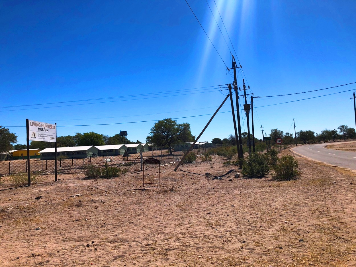 村の十字路から北に延びる道路D3315線。「Living Hunters Museumまで23キロ」という大きな看板がある(左手)。その後ろは村の中学校