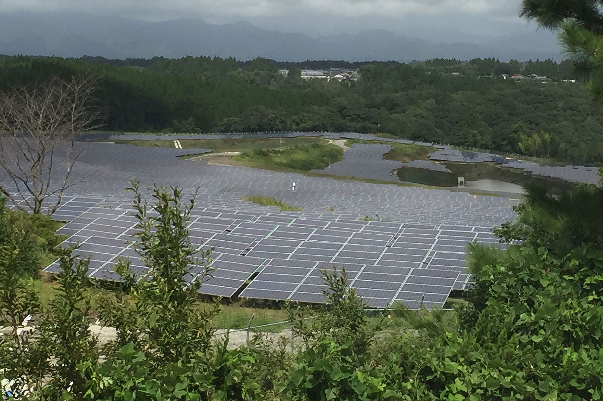 宮崎県国富町三名にある廃業したゴルフ場跡地にできたメガソーラー。運営事業者のNTTファシリティーズは工事も自前でおこない、かなり安く設備を作っていたという(現在はNTTアノードに移管・統合)。当時聞いたところ「企業秘密です」という回答だった。ここは、ほぼ元の地形をそのまま利用している。県内ではこうした案件が他にもある。© 中川修治